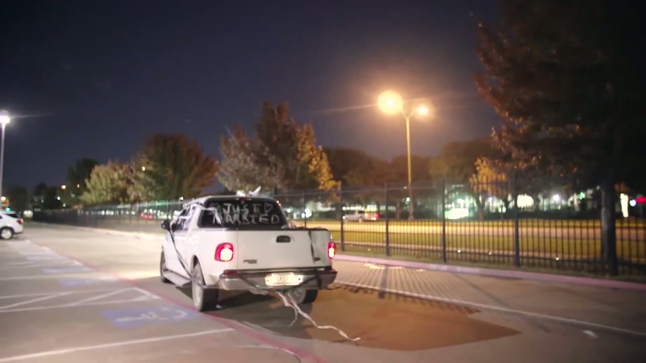 White getaway truck with a Just Married sign taped in the back window, parked at night
