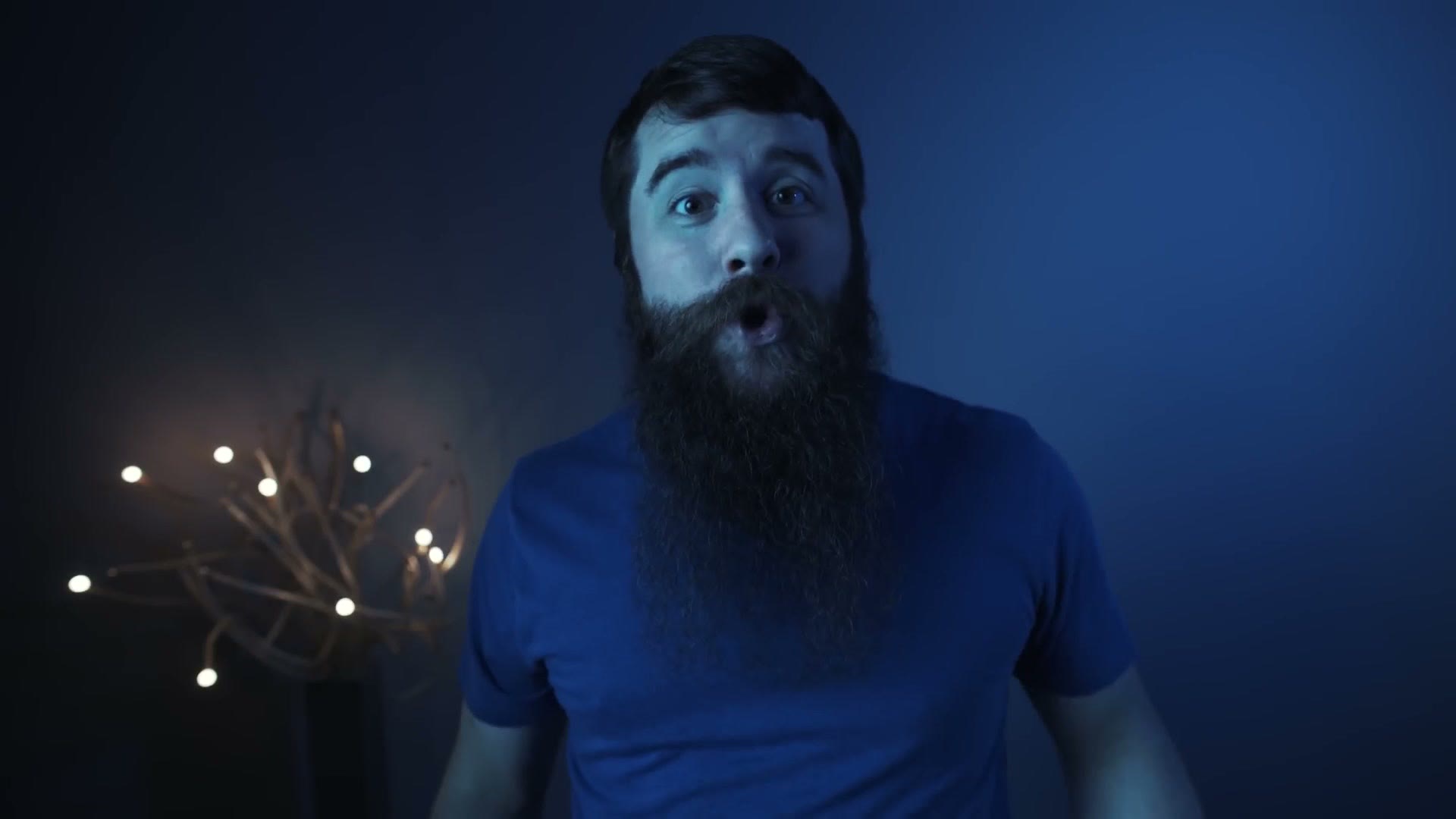 Matt sitting in front of a dark backdrop with the whole frame rendered heavily blue, his skin and shirt both washed cold.