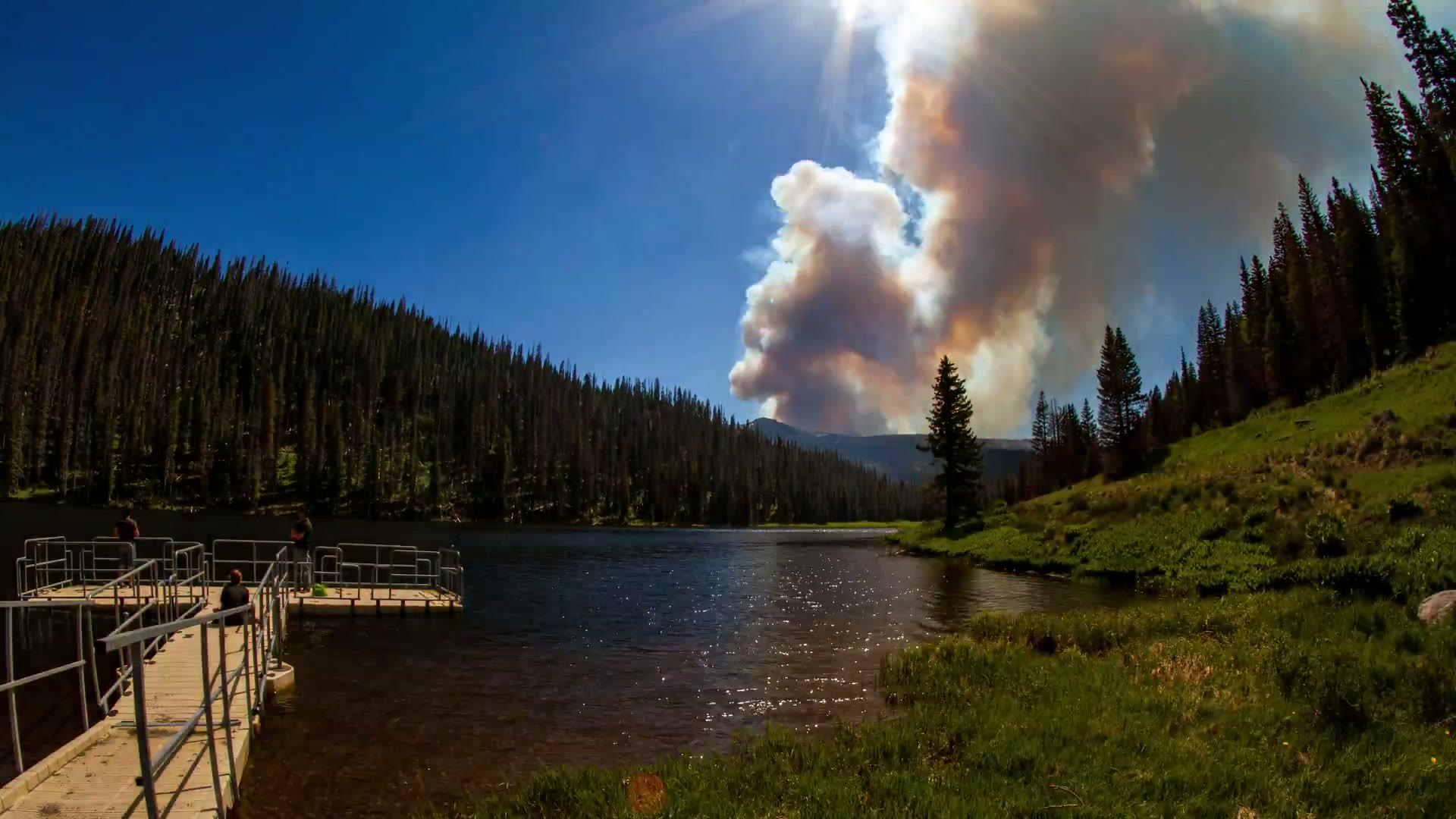Wildfire smoke rising above the same Colorado lake when it was still full
