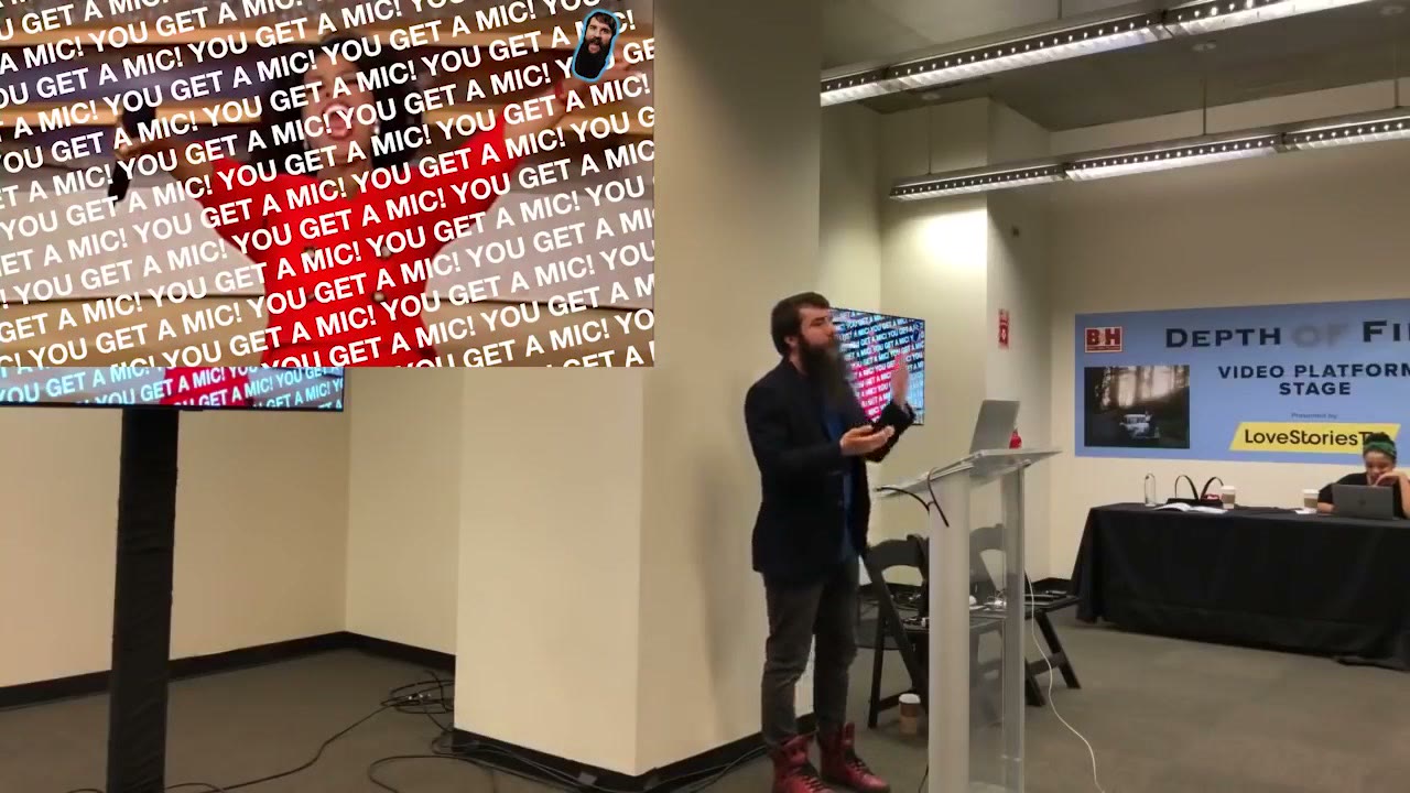 A conference slide filled edge to edge with the repeated words YOU GET A MIC in red, white and blue