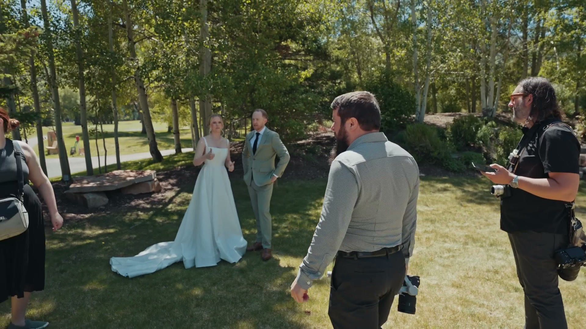 First look in a grove of aspens, the couple standing together while four photographers and videographers work around them