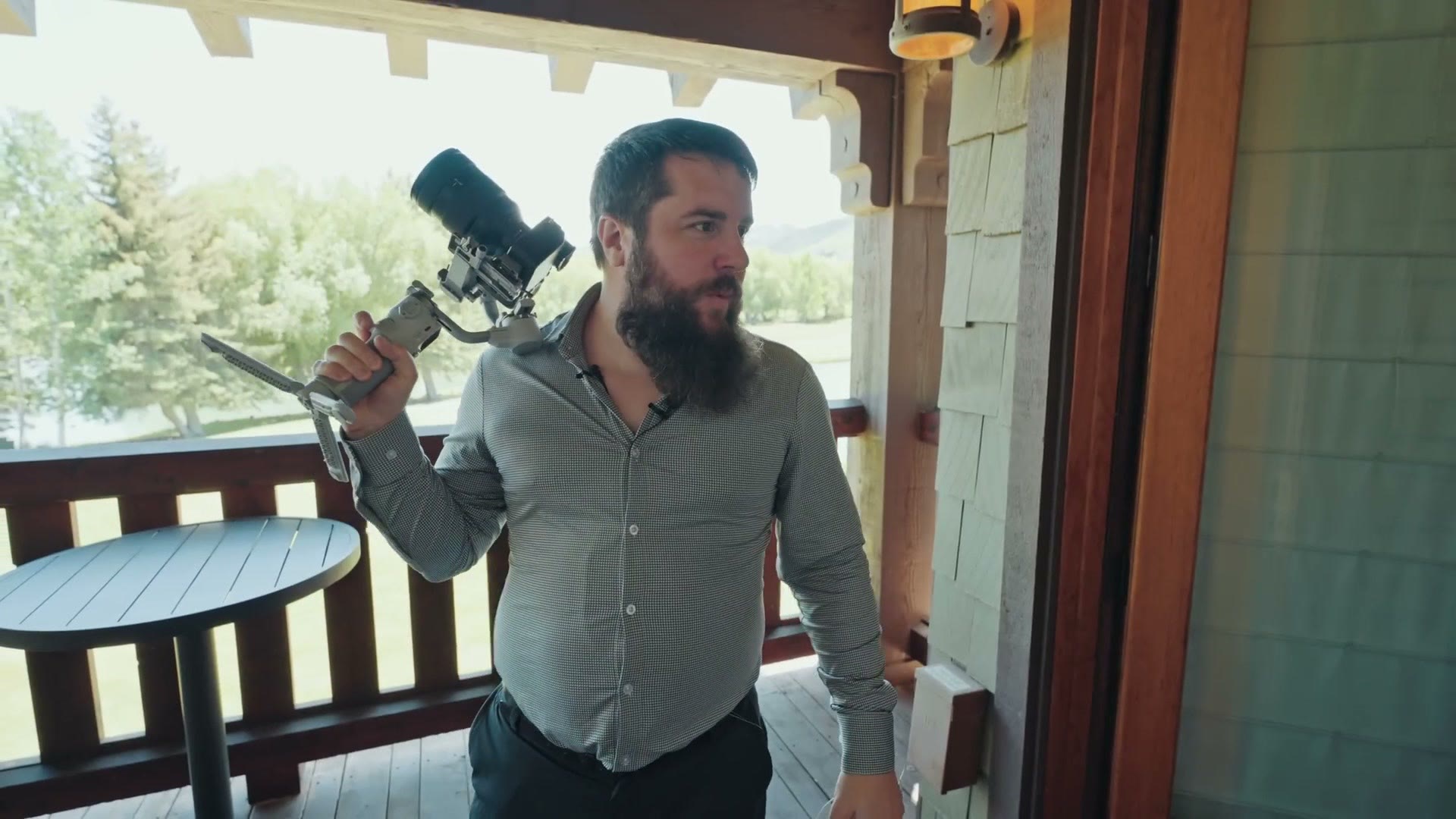 Matt standing on a balcony holding a camera on a gimbal over his shoulder