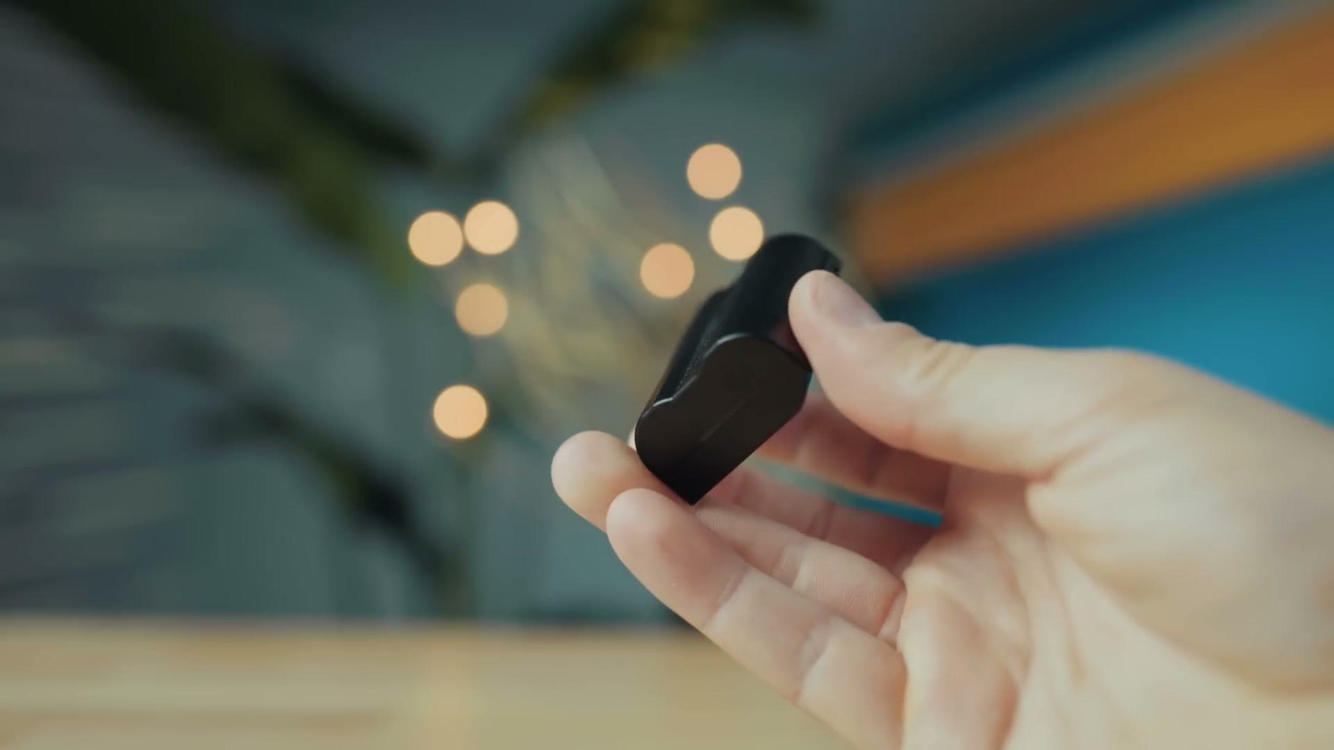 A Nikon camera battery held in one hand