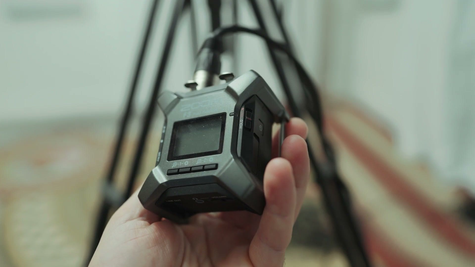 A Zoom F3 field recorder held in Matt's hand