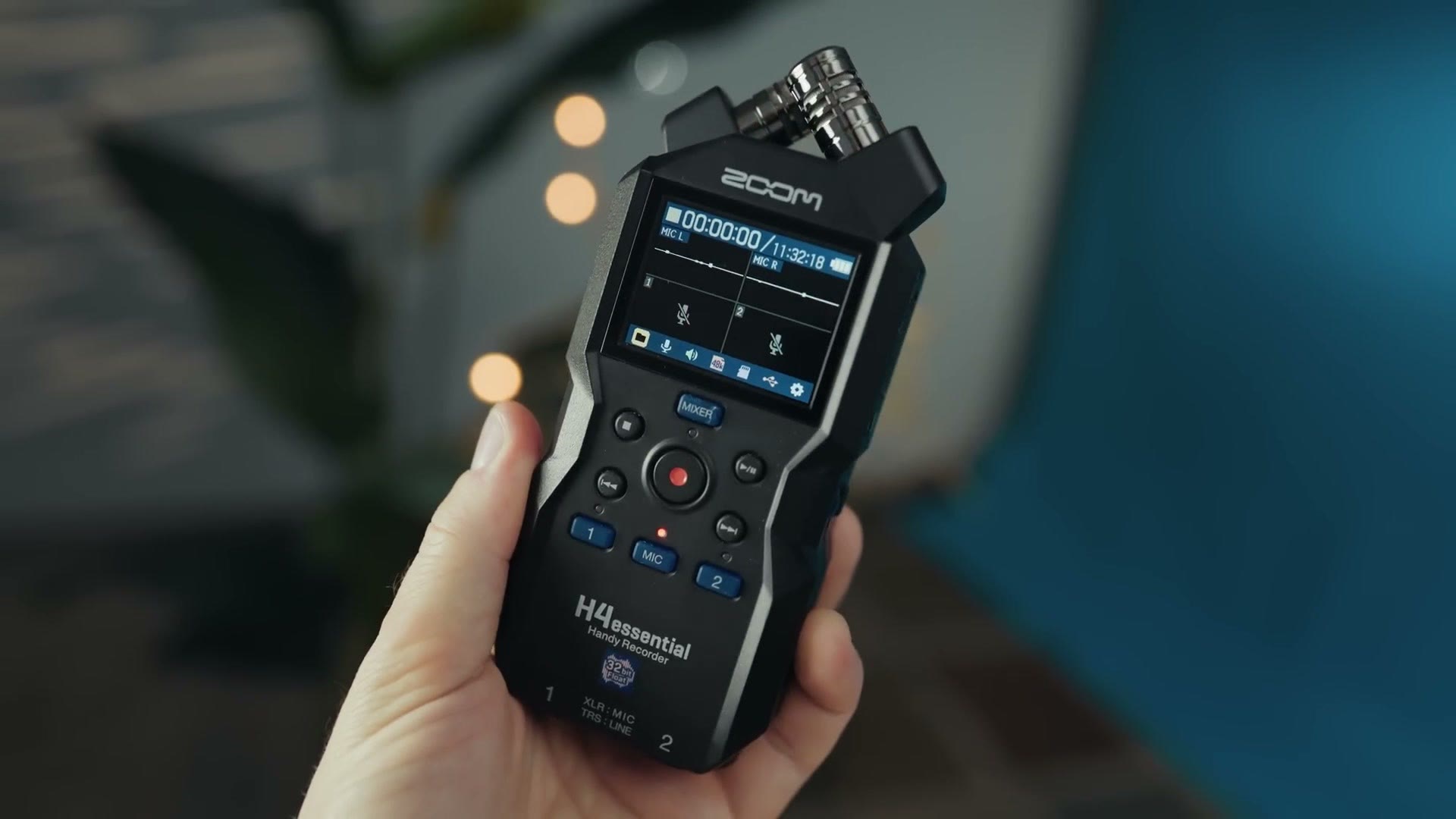 Zoom H4essential 32-bit float audio recorder held in hand