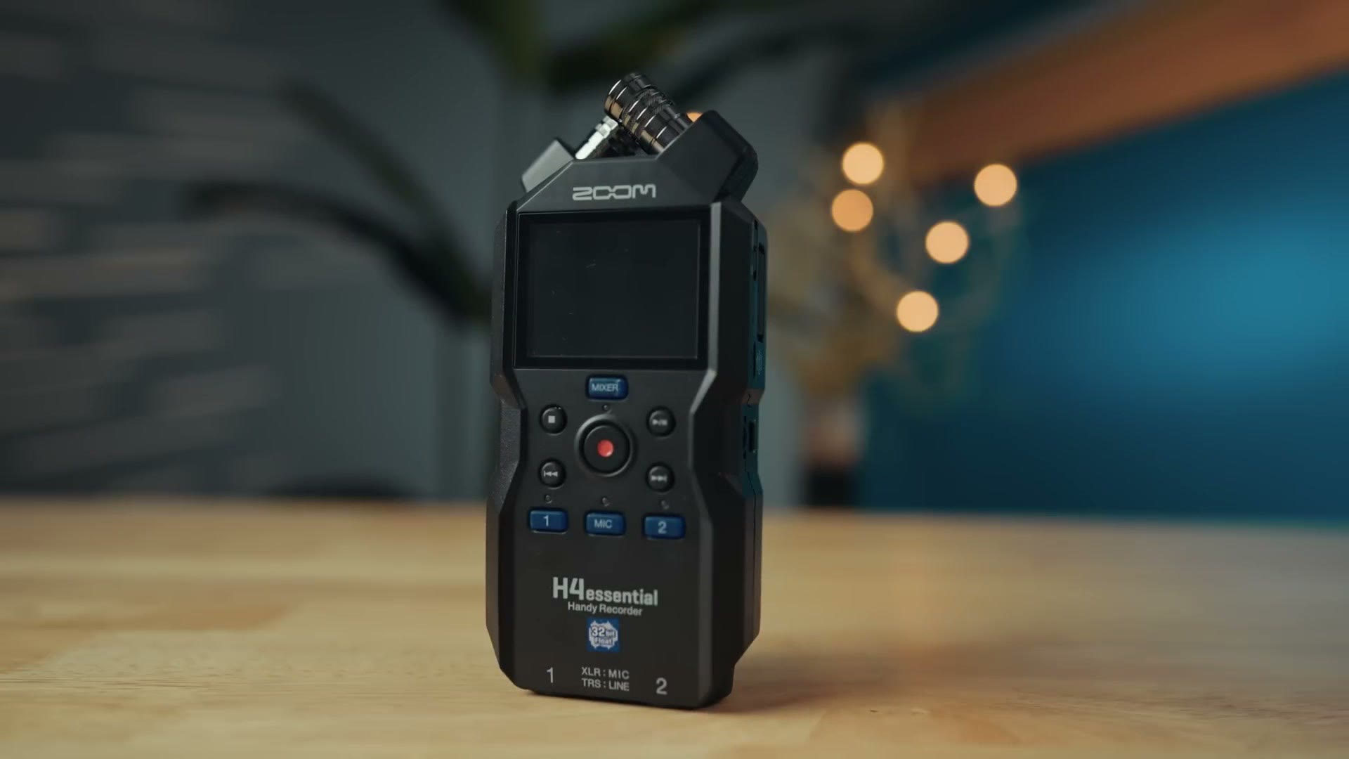 Zoom H4essential standing upright on a table with the 32-bit float sticker on the front