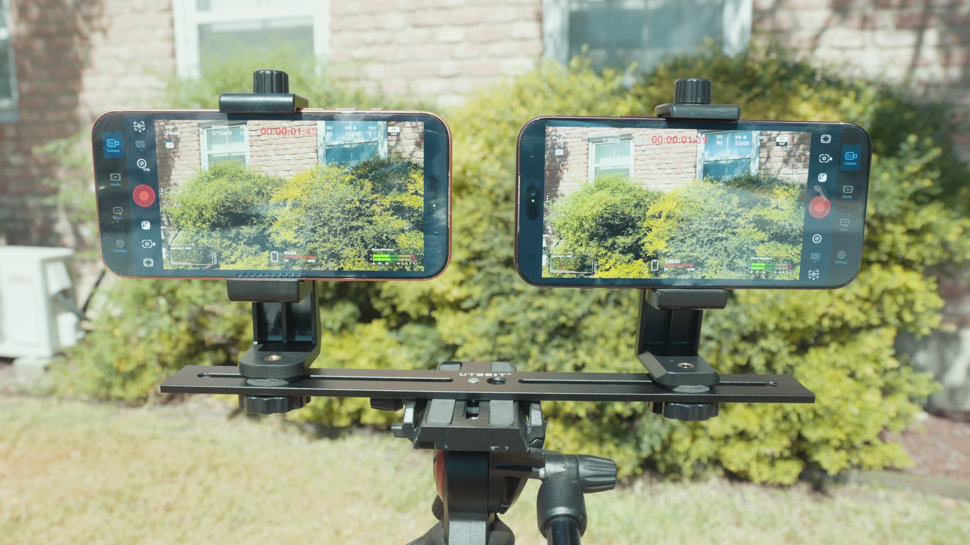 iPhone 18 Pro overheat test setup: the iPhone 17 Pro and iPhone 18 Pro mounted side by side on a tripod outdoors, both recording in the Blackmagic Camera app in direct sunlight