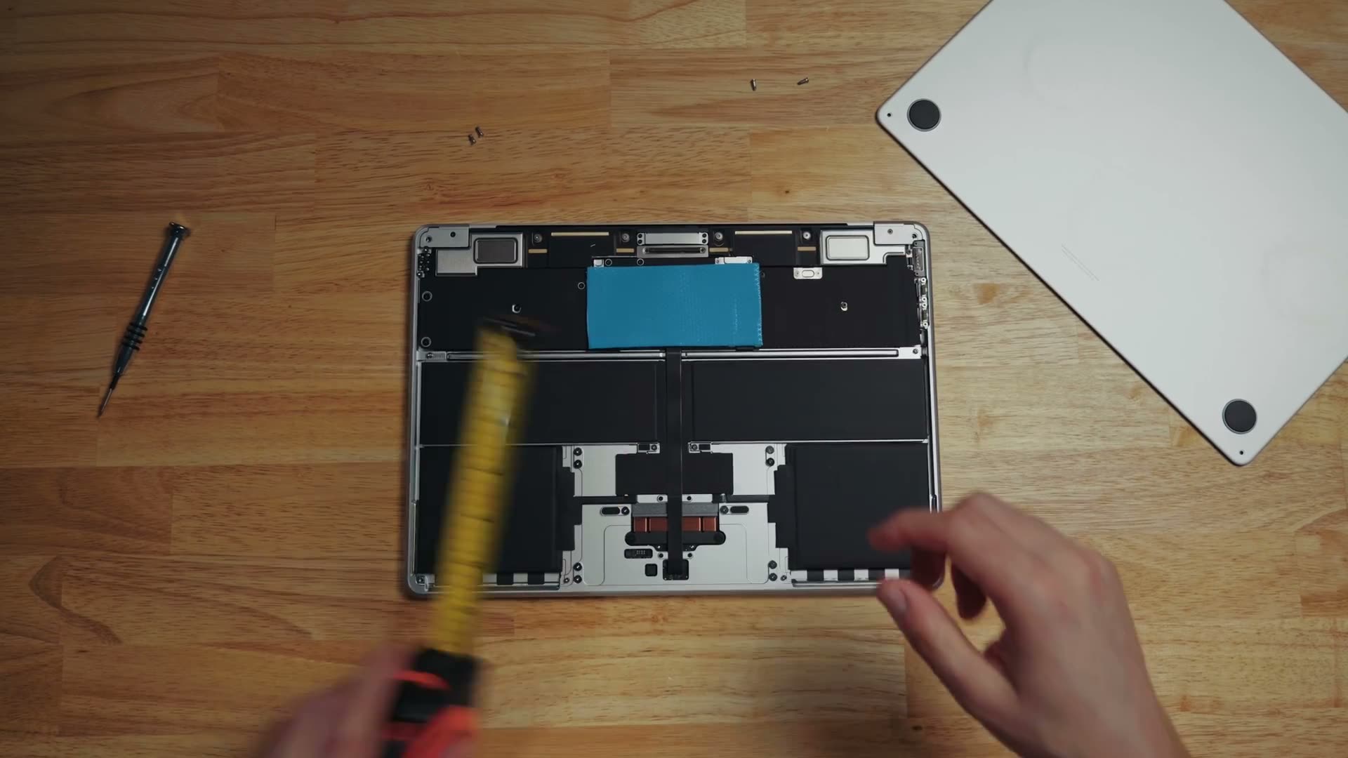 A blue thermal pad stuck onto the motherboard strip near the hinge inside an opened M5 MacBook Air