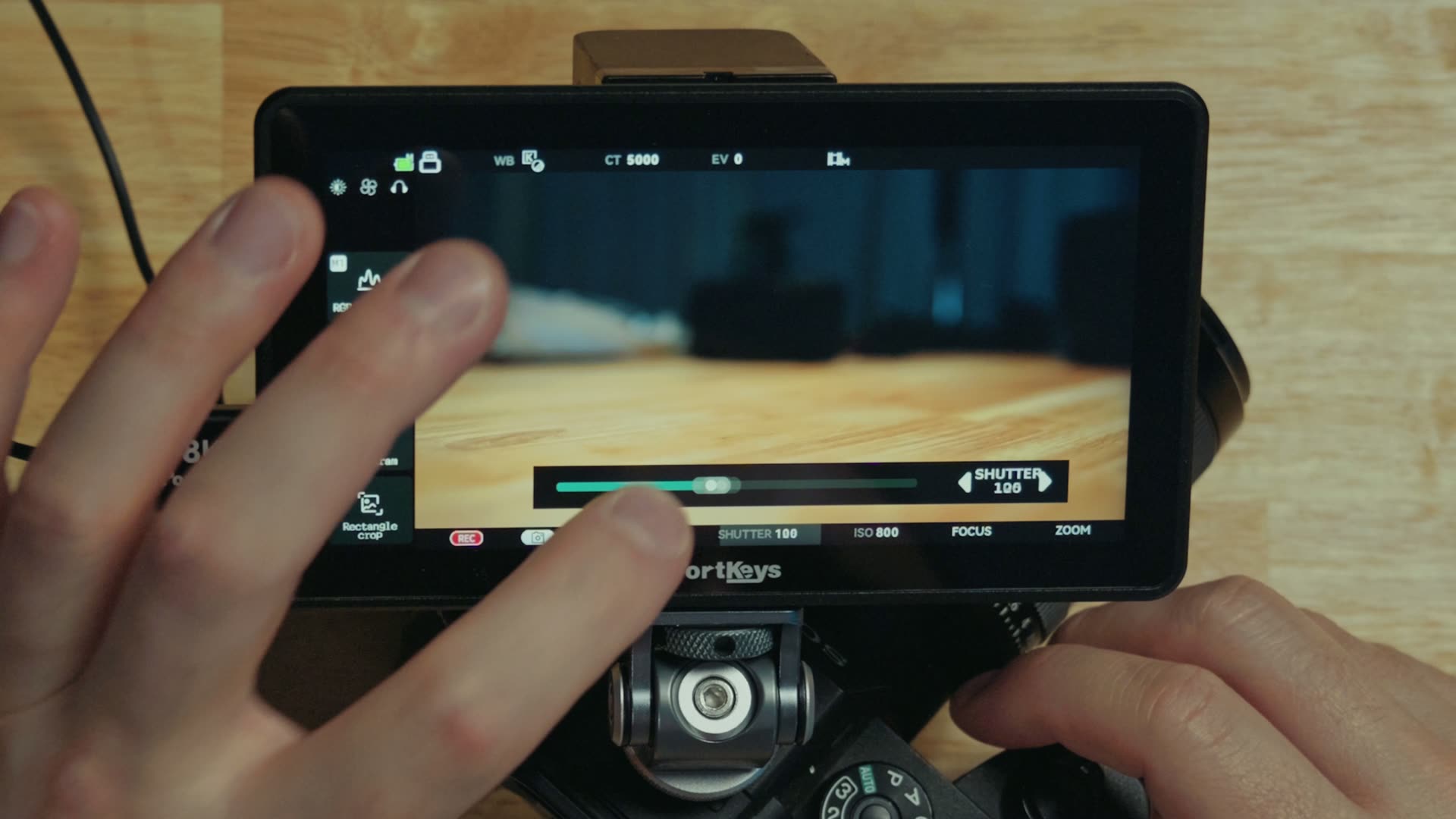 The camera control panel on the Portkeys LH5P III showing white balance, ISO and aperture over a live image