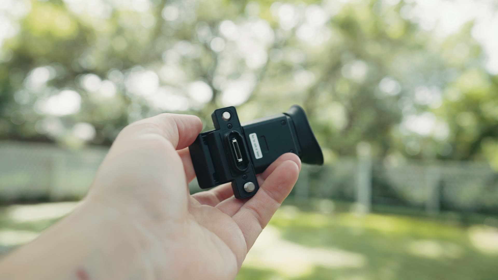 The detachable Sony FX5 electronic viewfinder held in hand outdoors