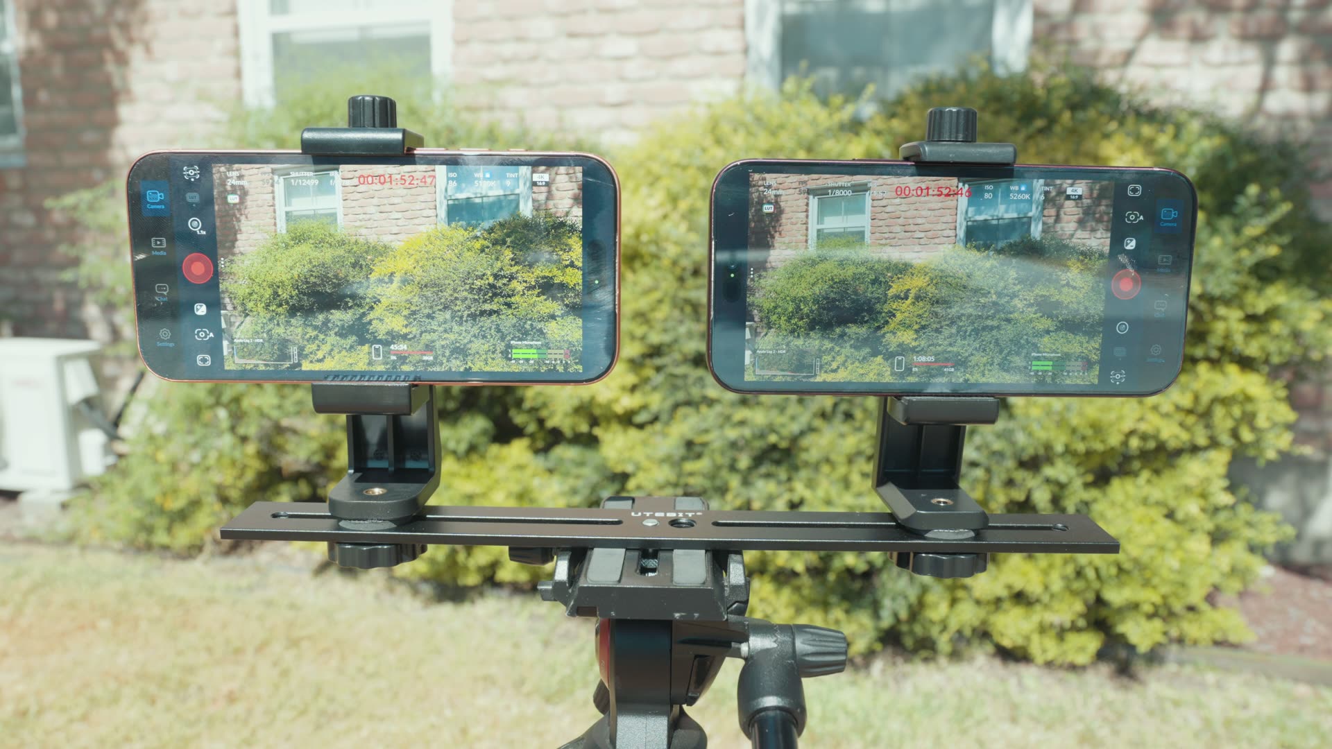 iPhone 18 Pro and iPhone 17 Pro mounted side by side on a tripod rig recording outdoors in bright sun