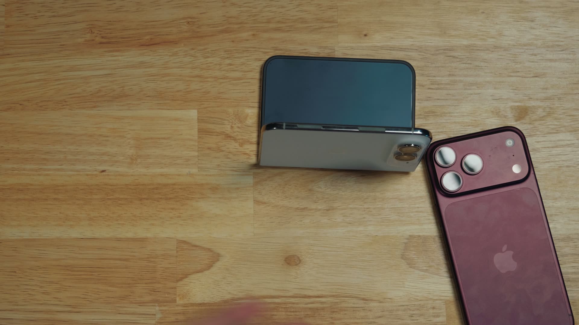 The iPhone Duo partially folded and standing upright on a wooden table, used as its own stand