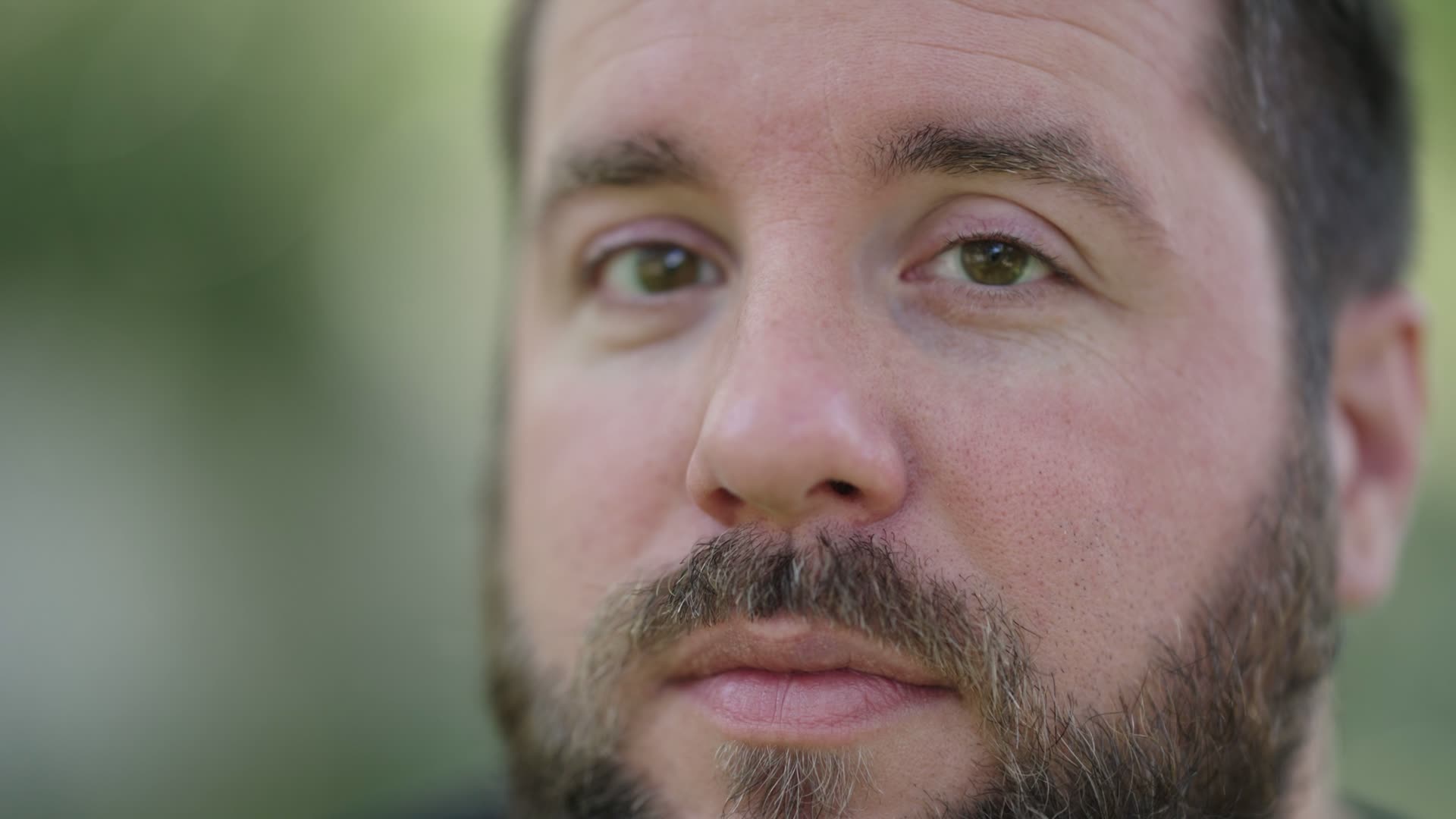 Extreme close-up filmed on the Sigma 85mm F1.2 at F1.2, with the eye in sharp focus and the beard and background falling off into blur