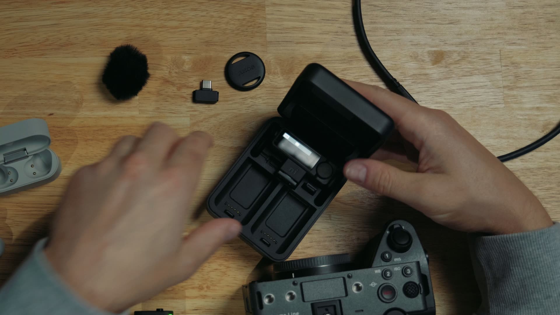 Sony ECM-W5 charging case holding the receiver with its camera hot shoe connector attached